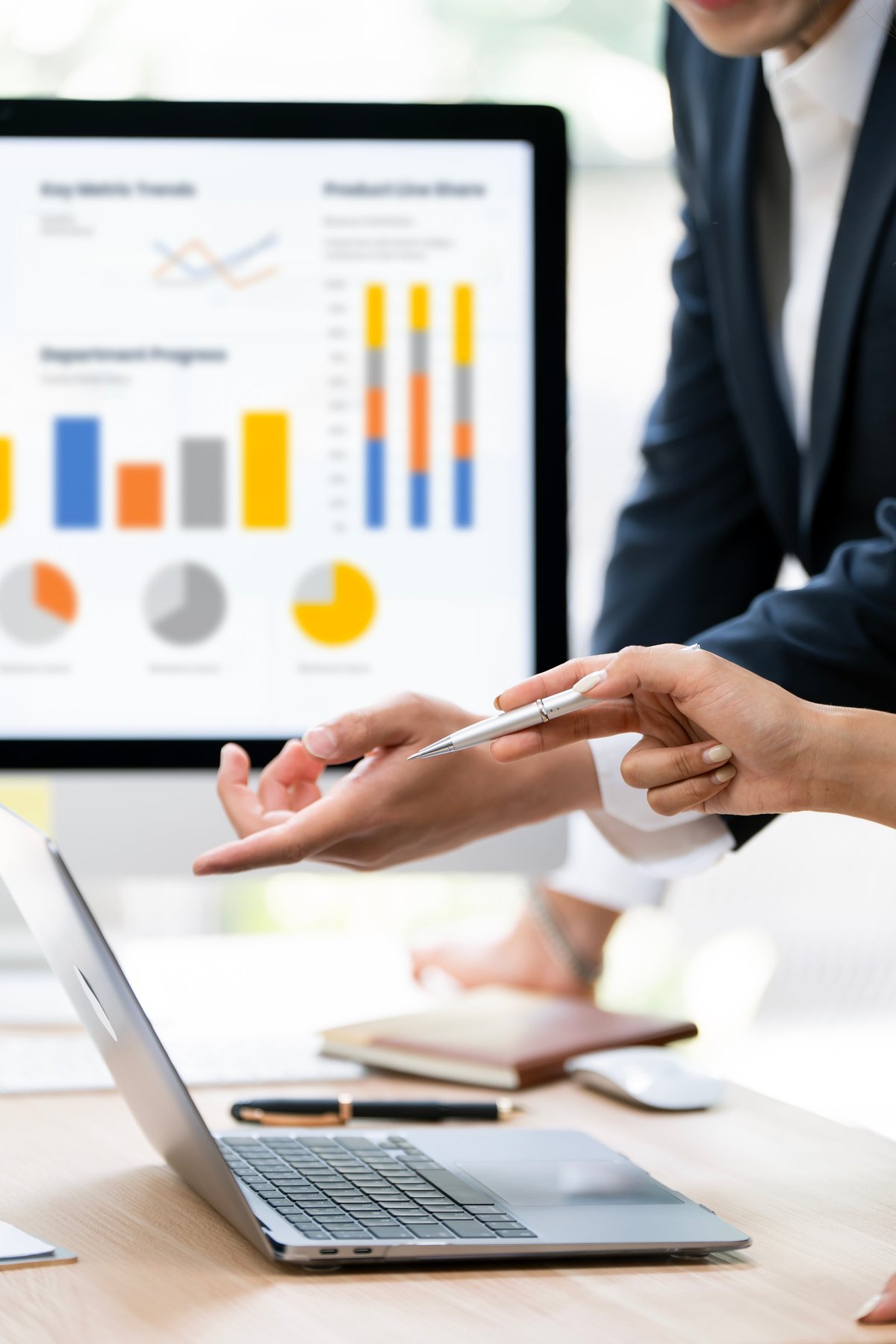 Two business partners reviewing a financial dashboard and charts on a laptop