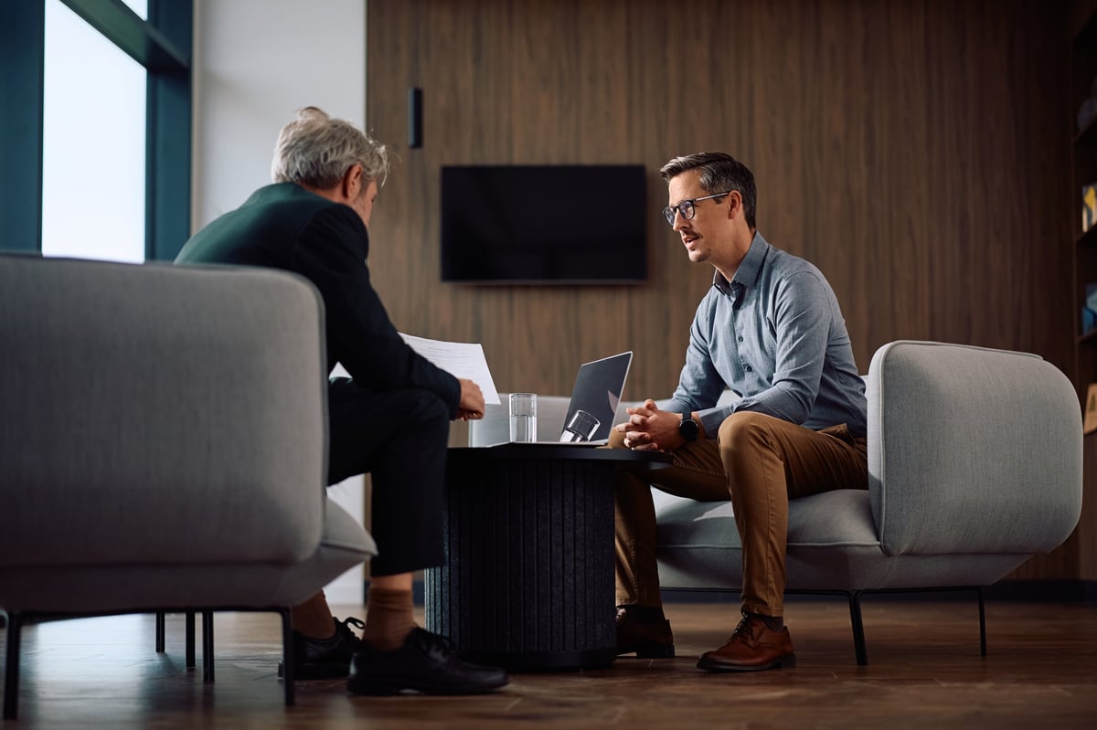 A business owner and an advisor analysing printed business reports together at a desk